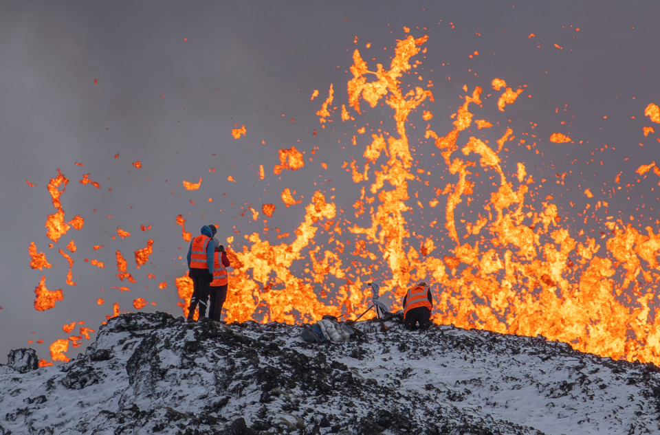 Scientists measurements and samples standing on the ridge of the volcano (AP)