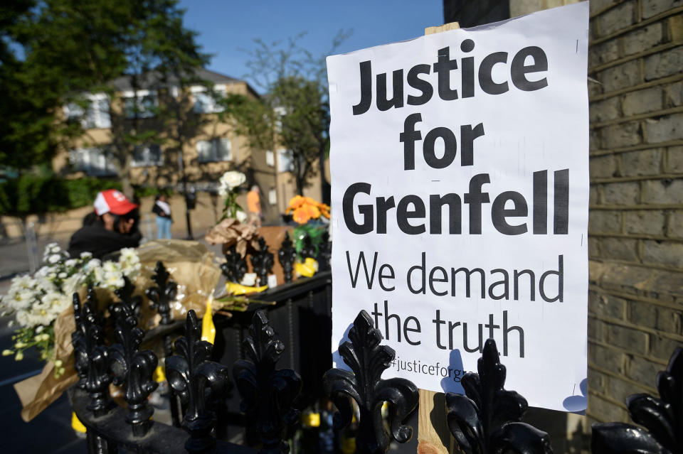 <p>A placard sits amongst flowers left for the victims of the Grenfell apartment tower block fire in North Kensington, London, Britain, June 17, 2017. (Hannah McKay/Reuters) </p>