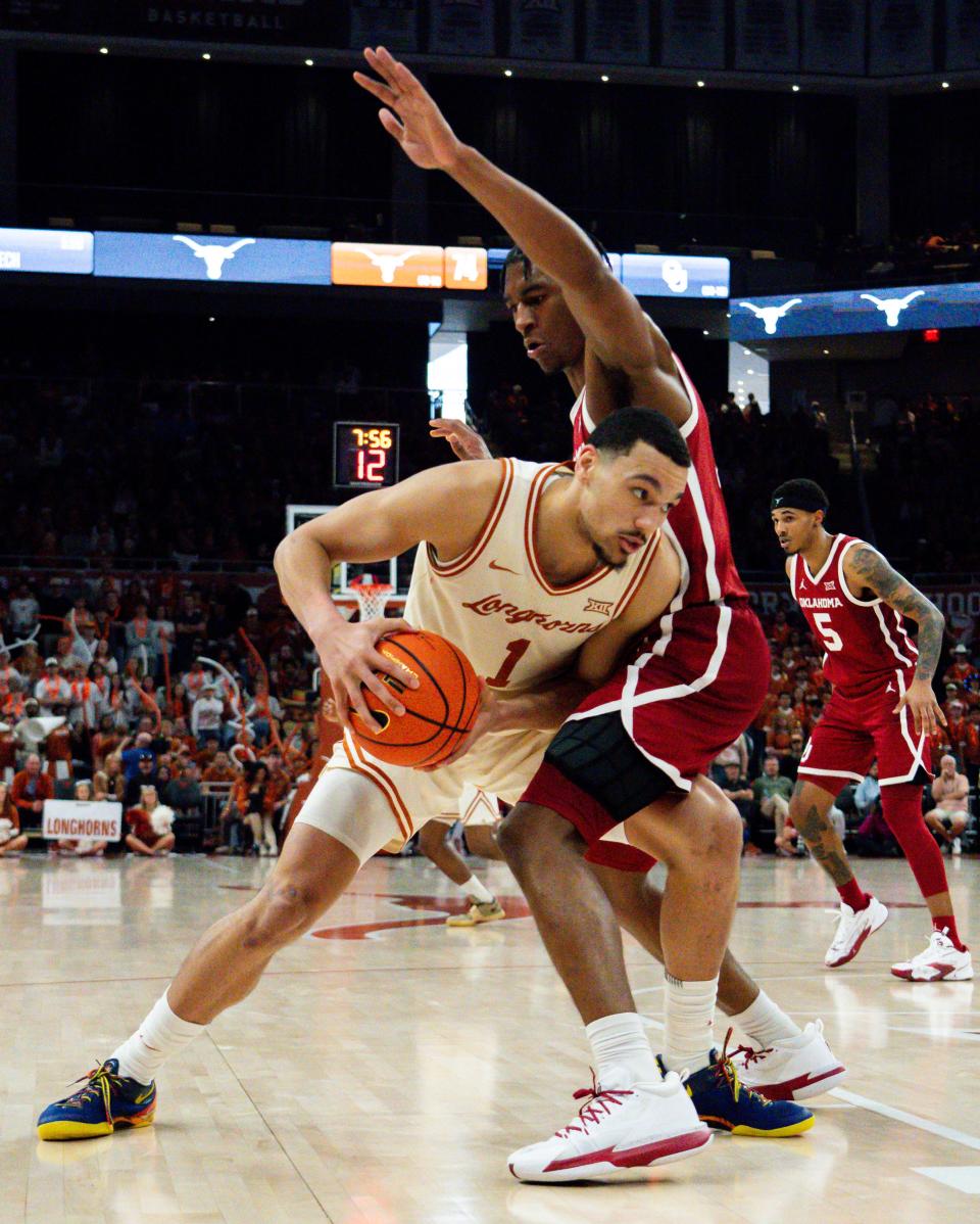 Texas forward Dylan Disu battles Oklahoma's Jalon Moore as he tries to find a path to the basket during the second half of the Longhorns' 94-80 win over Oklahoma in the regular-season finale at Moody Center. The Longhorns now wait to find out who they'll open with at next week's Big 12 Tournament.