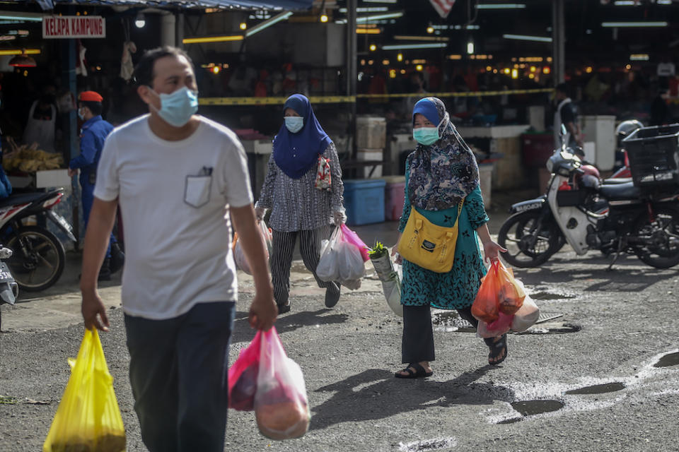 People shop for essential goods at the Chow Kit market during the movement control order in Kuala Lumpur April 5, 2020. — Picture by Firdaus Latif