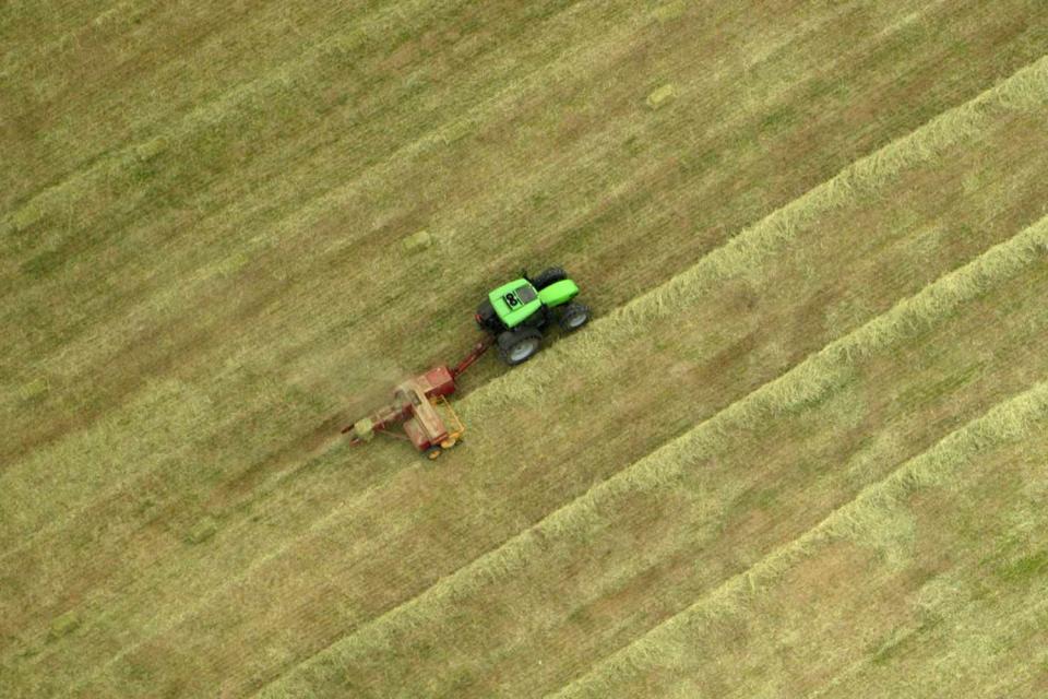 <p>Getty Images</p> An aerial view of the patterns created as a farmer on a tractor bales hay on a field near Hendersonville, North Carolina