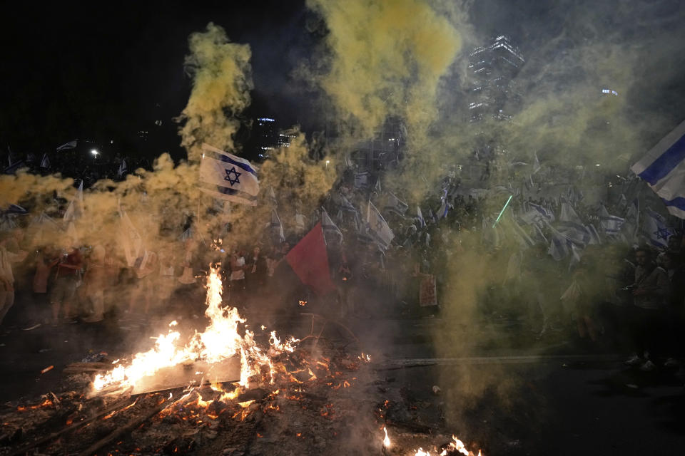 Israelis opposed to Prime Minister Benjamin Netanyahu's judicial overhaul plan set up bonfires and block a highway during a protest moments after the Israeli leader fired his defense minister, in Tel Aviv, Israel, Sunday, March 26, 2023. Defense Minister Yoav Gallant had called on Netanyahu to freeze the plan, citing deep divisions in the country and turmoil in the military. (AP Photo/Ohad Zwigenberg)
