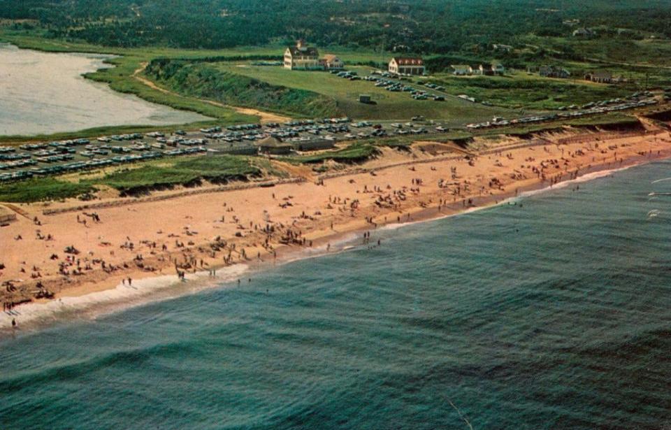 A postcard aerial image of Coast Guard Beach in Eastham from the 1960s. The parking lot seen in the image was swept away by a storm in 1978.