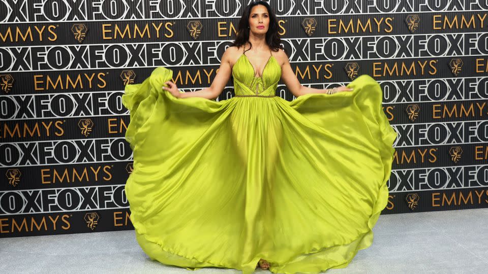 Television host Padma Lakshmi arrives in a neon green goddess gown with gold bodice trimming by New York label Marchesa. - Aude Guerrucci/Reuters