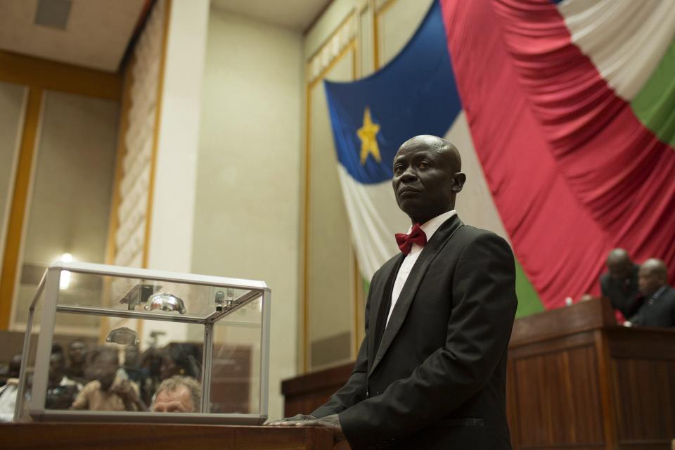 A man stands beside a glass ballot box before supervising parliamentary elections at the national assembly in Bangui