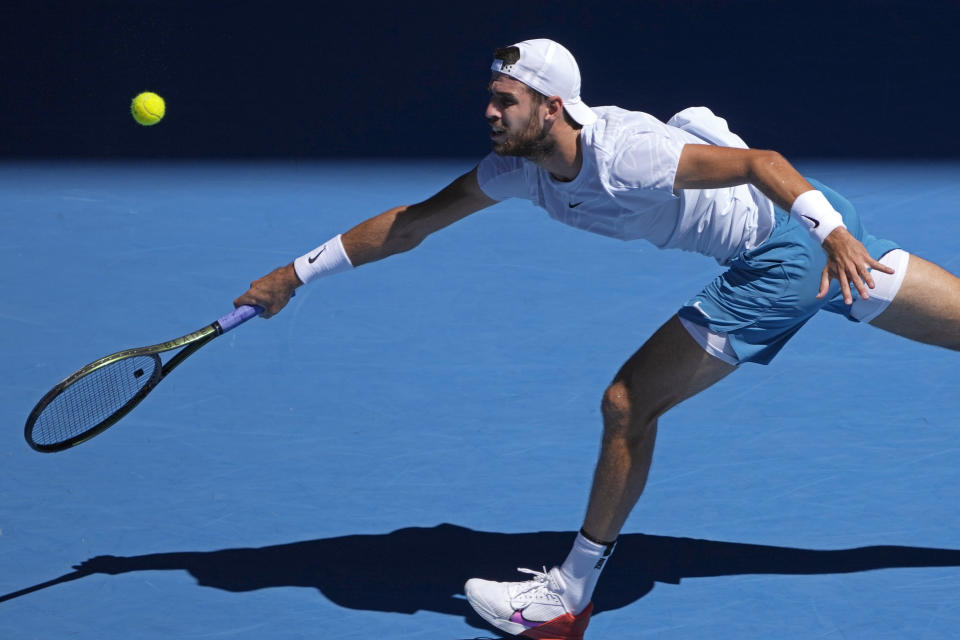 Karen Khachanov, de Rusia, devuelve un golpe al griego Stefanos Tsitsipas en la semifinal del Abierto de Australia, en Melbourne, Australia, el 27 de enero de 2023.(AP Foto/Ng Han Guan)