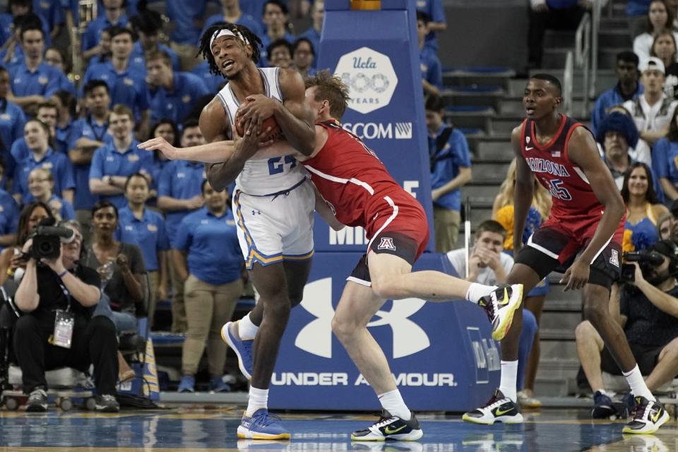 Jalen Hill and Arizona's Stone Gettings grapple for the basketball.