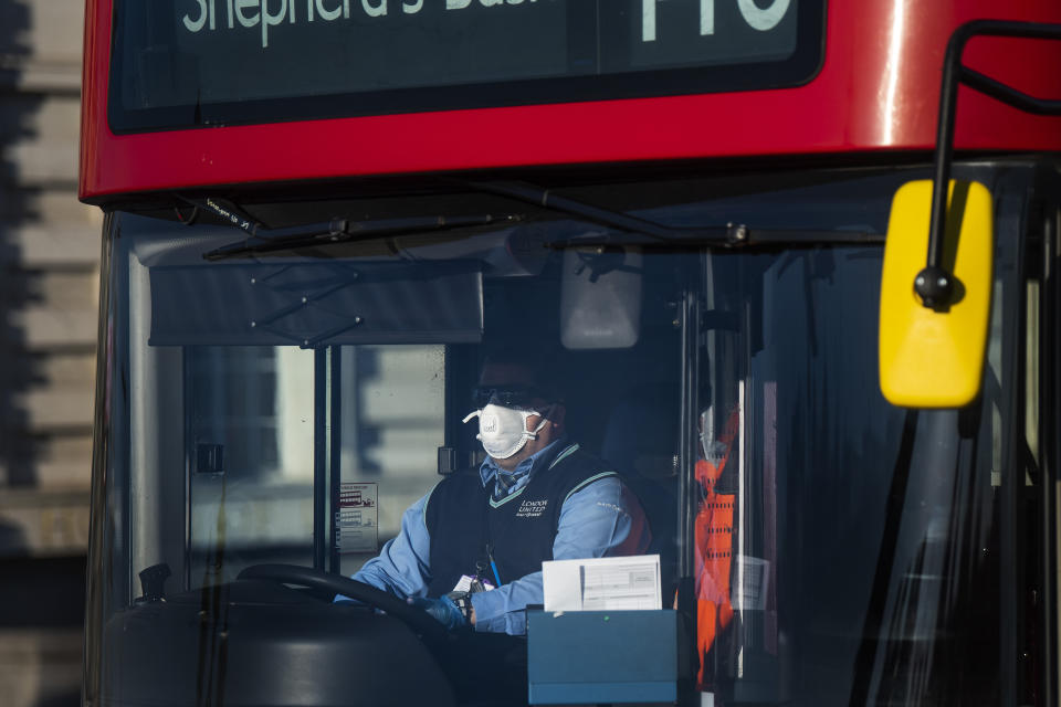 A London bus driver wearing a protective face mask on Westminster Bridge, London, after Prime Minister Boris Johnson made the decision to put the UK in lockdown to help curb the spread of the coronavirus.