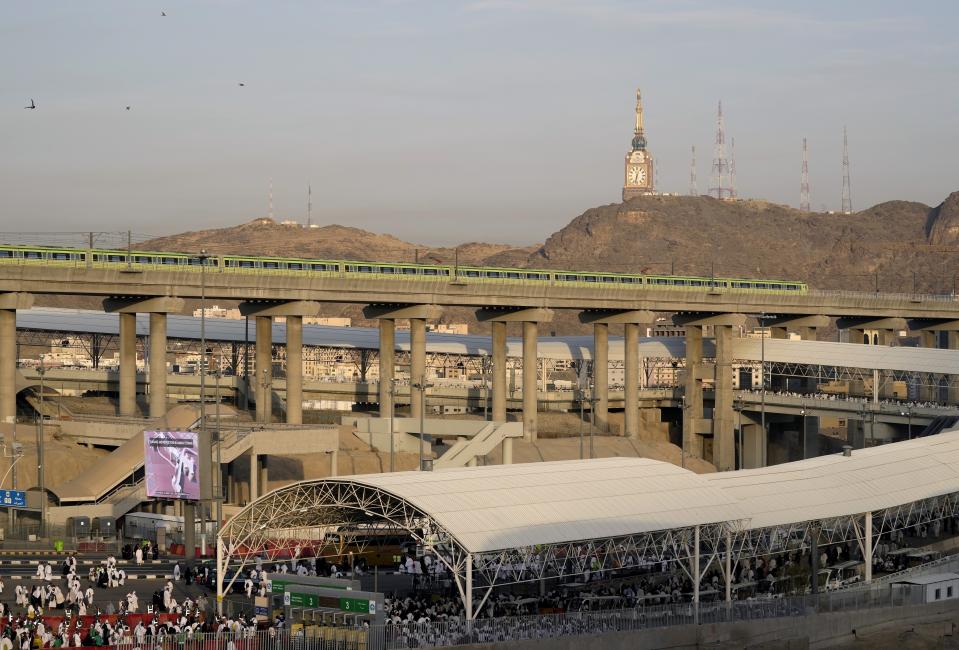 A Mecca Metro train passes the world tallest clock tower during the Hajj pilgrimage, in Mina near the city of Mecca, Saudi Arabia, Saturday, July 9, 2022. (AP Photo/Amr Nabil)