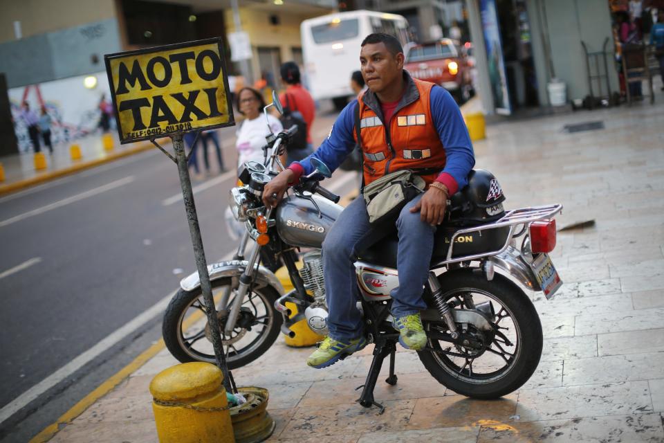 A motorcycle taxi driver waits for customers in downtown Caracas