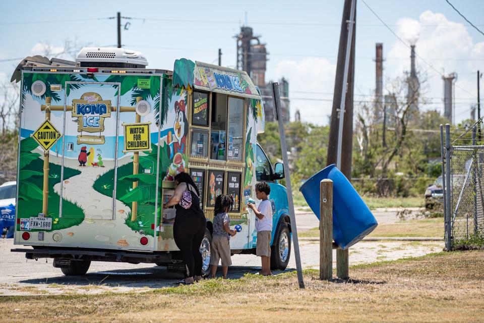 Dorales Burns, and sons, from left, Lee, 7, and Craig Henderson, 8, get tropical shaved ice from a mobile truck during Juneteenth for the Crest Family Fun Day at H.J. Williams Memorial Park in Corpus Christi, on Sunday, June 19, 2022.