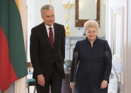 Lithuania's President Dalia Grybauskaite and Lithuanian President-elect Gitanas Nauseda, left, walk together prior to their meeting at the President's palace in Vilnius, Lithuania, Monday, May 27, 2019. (AP Photo/Mindaugas Kulbis)