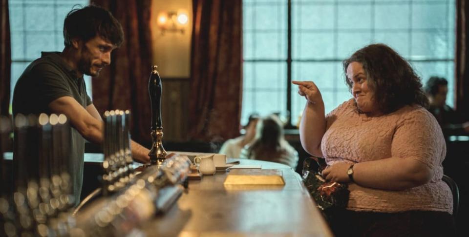 A scene from Baby Reindeer: Martha points at Donnie Dunn across the bar