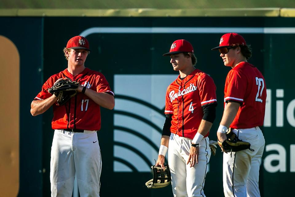 Western Dubuque's Brett Harris, left, talks with teammates Caleb Klein, center, and Clayten Lindecker during a high school baseball game against Cedar Rapids Kennedy on May 30 in Farley.