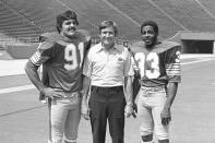 FILE - In this Aug. 23, 1976, file photo, University of Pittsburgh head coach Johnny Majors is shown with All-American halfback Heisman Trophy candidate Tony Dorsett, right, and middle guard Al Romano, left, during Fan Appreciation Day at Pitt Stadium in Pittsburgh. Majors, the coach of Pittsburgh’s 1976 national championship team and a former coach and star player at Tennessee, has died. He was 85. Majors died Wednesday morning, June 3, 2020, at home in Knoxville, Tenn., according to a statement from his wife, Mary Lynn Majors. (AP Photo/MK, File)