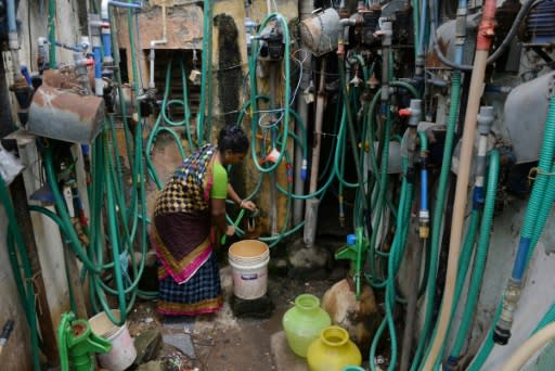An Indian resident fills a bucket with water from a tap at a residential complex in Chennai on June 26, 2019