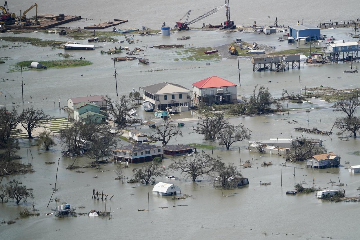 FILE - Buildings and homes are flooded in the aftermath of Hurricane Laura Thursday, Aug. 27, 2020, near Lake Charles, La. In the past year, the southwestern Louisiana city of Lake Charles weathered two hurricanes, intense rainfall that sent water gushing down streets and a deep freeze that burst pipes. Under a revamped federal flood insurance program rolled out in the fall of 2021, millions of homeowners are set for rate hikes that officials say more accurately reflect a property’s risk. (AP Photo/David J. Phillip, File)