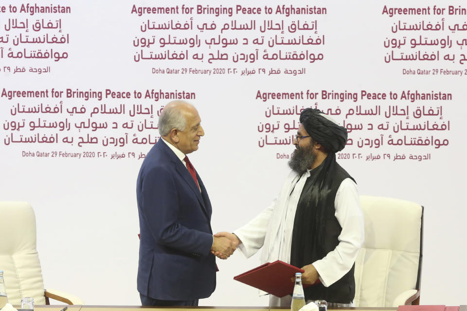 U.S. peace envoy Zalmay Khalilzad, left, and Mullah Abdul Ghani Baradar, the Taliban group's top political leader shack hands after signing a peace agreement between Taliban and U.S. officials in Doha, Qatar, Saturday, Feb. 29, 2020. The United States is poised to sign a peace agreement with Taliban militants on Saturday aimed at bringing an end to 18 years of bloodshed in Afghanistan and allowing U.S. troops to return home from America's longest war. (AP Photo/Hussein Sayed)