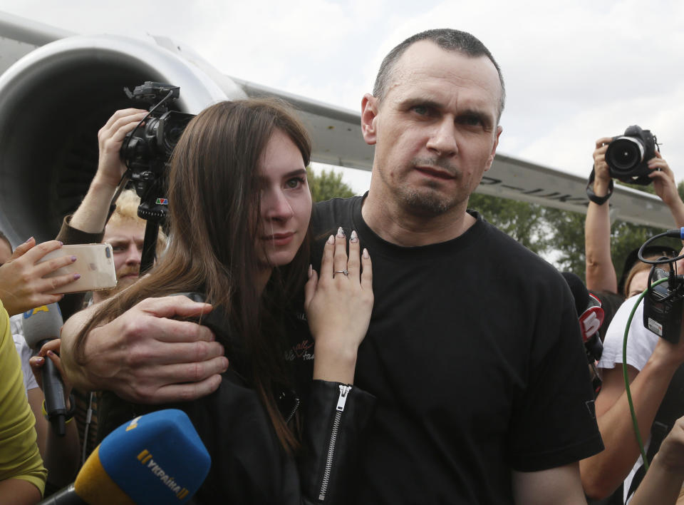 Ukrainian filmmaker Oleg Sentsov hugs his daughter upon his arrival at Boryspil airport, outside Kyiv, Ukraine, Saturday, Sept. 7, 2019. Planes carrying prisoners freed by Russia and Ukraine have landed in the countries' capitals, in an exchange that could be a significant step toward improving relations between Moscow and Kyiv. The planes, each reportedly carrying 35 prisoners, landed almost simultaneously at Vnukovo airport in Moscow and at Kyiv's Boryspil airport. (AP Photo/Efrem Lukatsky)