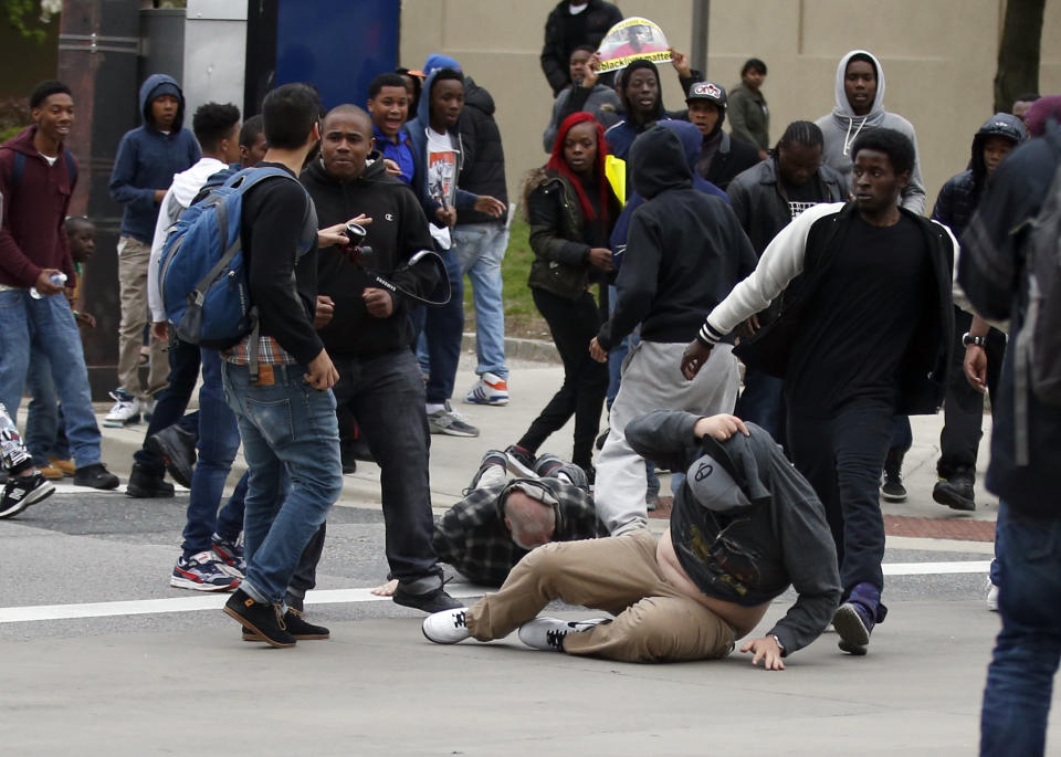 Two men are on the ground after being struck after a march to City Hall for Freddie Gray, Saturday, April 25, 2015 in Baltimore. Gray died from spinal injuries about a week after he was arrested and transported in a police van. (AP Photo/Alex Brandon)