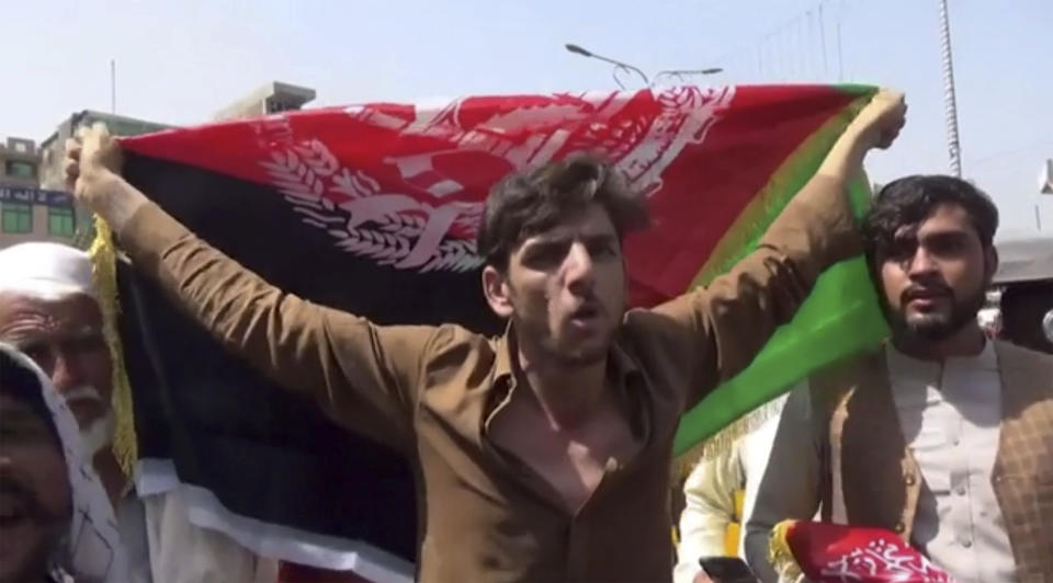 A man holds the flag of Afghanistan during a protest in Jalalabad on Wednesday, Aug. 18, 2021. Taliban militants have attacked protesters in eastern Afghanistan who dared to take down their banner and replace it with the country’s flag. At least one person was killed in the attack that fueled fears about how the insurgents would govern this fractious nation. (AP Photo)