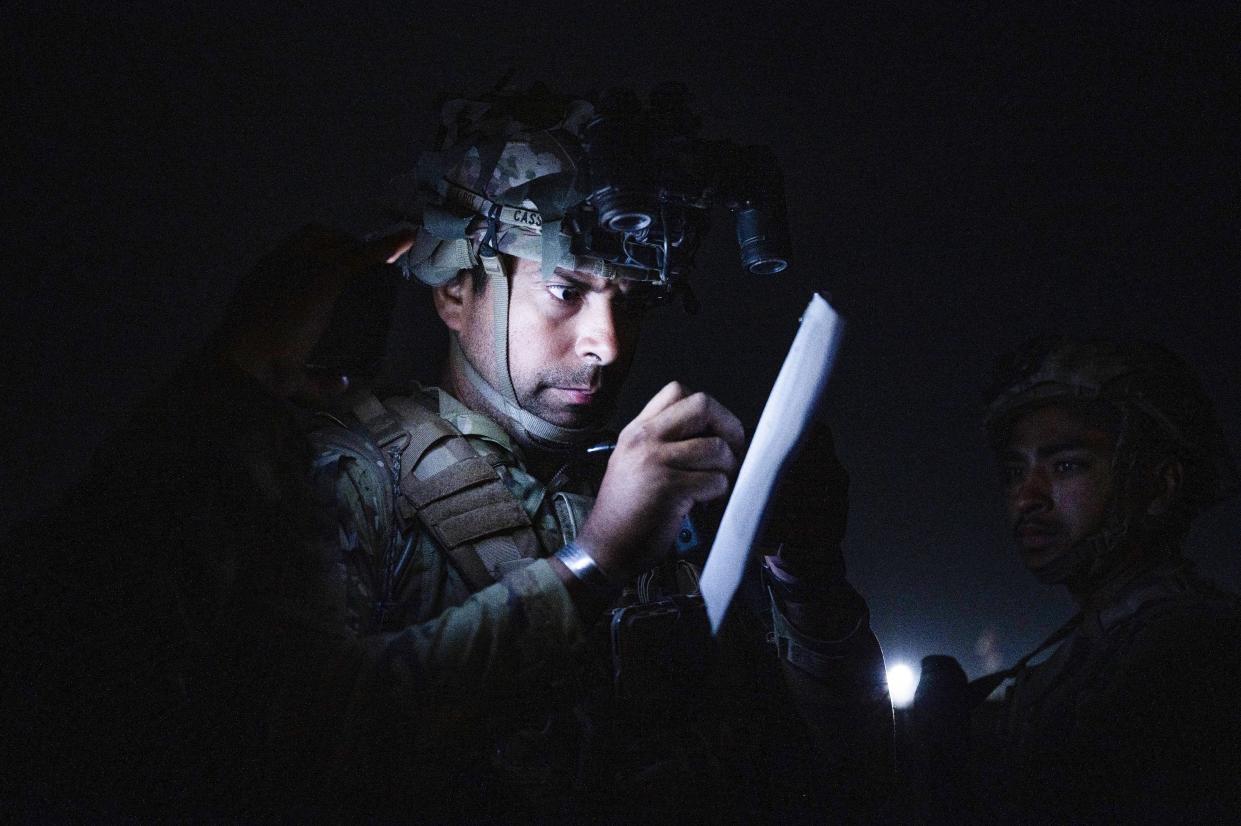 In this Aug. 30, 2021, photo provided by the U.S. Air Force, a soldier, assigned to the 82nd Airborne Division, signs a piece of paper in support of the final noncombatant evacuation operation missions at Hamid Karzai International Airport in Kabul, Afghanistan. 