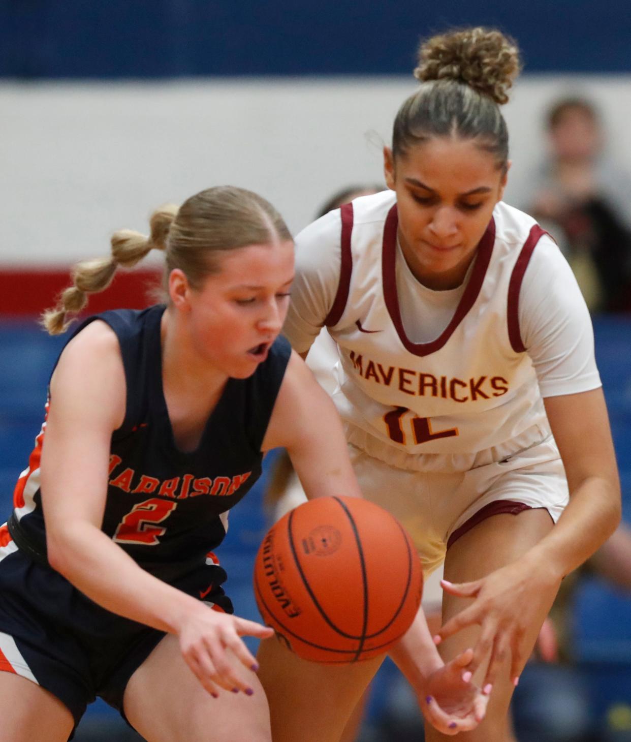 Harrison Raiders Ava Ahnert (2) and McCutcheon Mavericks Lillie Graves (12) go for a loose ball during the IHSAA girl’s basketball sectional championship game, Saturday, Feb. 3, 2024, at Kokomo Memorial Gymnasium in Kokomo, Ind.