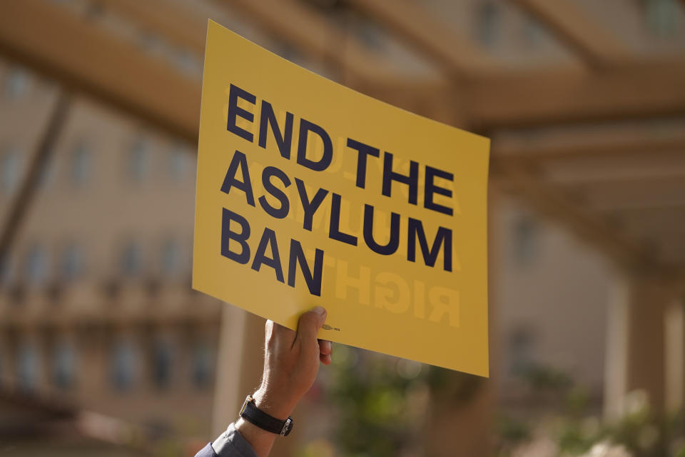 A demonstrator holds a sign outside of the Richard H. Chambers U.S. Court of Appeals ahead of an asylum hearing ,Tuesday, Nov. 7, 2023, in Pasadena, Calif. (AP Photo/Marcio Jose Sanchez)