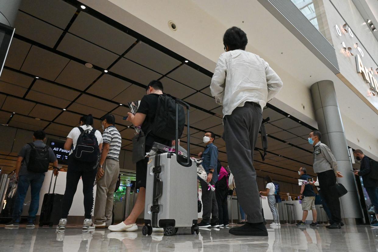 Passengers queue at an immigration checkpoint at the Singapore Changi Airport.