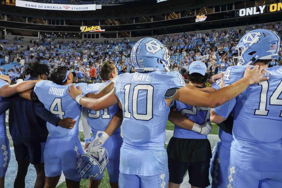 Sep 2, 2023; Charlotte, North Carolina, USA; North Carolina Tar Heels quarterback <a class="link " href="https://sports.yahoo.com/ncaaf/players/322656" data-i13n="sec:content-canvas;subsec:anchor_text;elm:context_link" data-ylk="slk:Drake Maye;sec:content-canvas;subsec:anchor_text;elm:context_link;itc:0">Drake Maye</a> (10) stands with teammates for the UNC alma mater after defeating the South Carolina Gamecocks at Bank of America Stadium. Mandatory Credit: Jim Dedmon-USA TODAY Sports