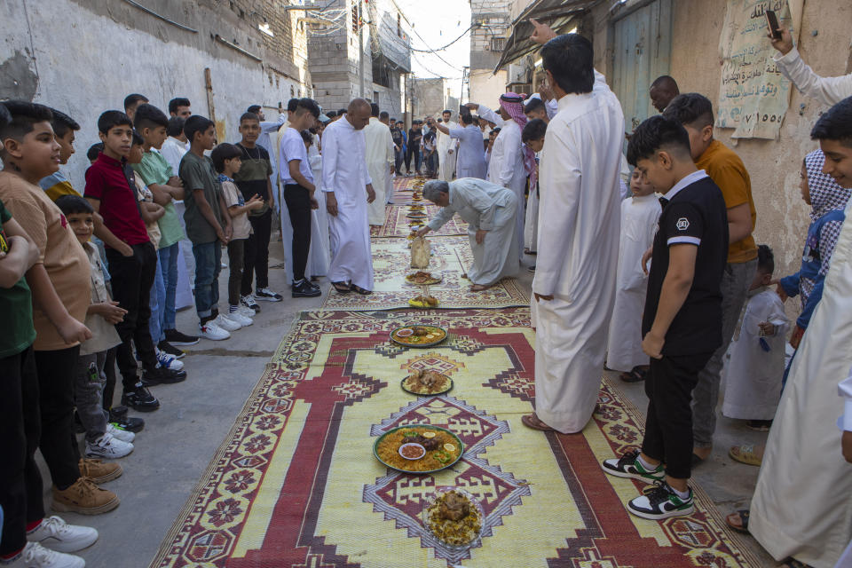 Iraqis eat morning breakfast on the first day of Eid Al-Fitr holiday in Basra, Iraq, Friday, April 21, 2023. Eid Al-Fitr marks the end of the Muslim holy fasting month of Ramadan. (AP Photo/Nabil al-Jurani)