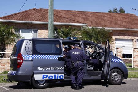 Police talk as they guard a house that was involved in pre-dawn raids in western Sydney September 18, 2014. REUTERS/David Gray