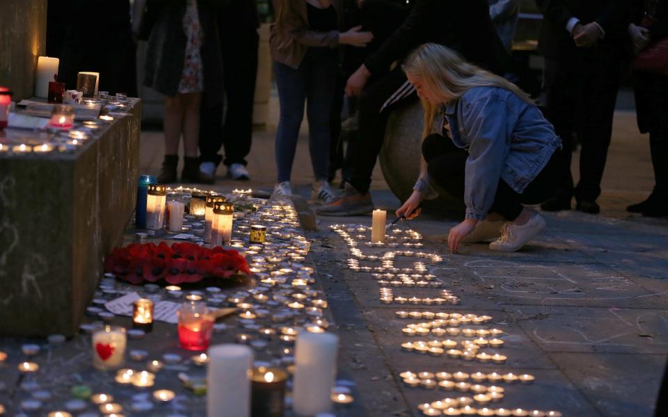 People pay their respects for the victims of the Manchester bombing during a vigil at St Ann's Square in Manchester - Credit: Nigel Roddis /EPA