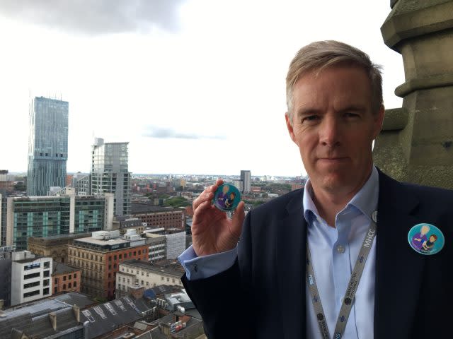 Manchester Health and Care Commissioning chief accountable officer Ian Williamson with the new badge  launched by Girlguides in Manchester to tackle loneliness in old people