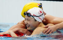 Canada's Margaret MacNeil celebrates her gold medal swim in the women's 100-meter butterfly final with Sweden's Sarah Sjoestroem during the Tokyo Olympics in Tokyo, Japan, Monday, July 26, 2021. (Frank Gunn/The Canadian Press via AP)