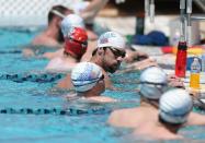 Michael Phelps (C) rests as he practices for the Arena Grand Prix at the Skyline Aquatic Center in Mesa, Arizona on April 23, 2014