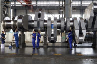 In this July 24, 2019, photo, workers wipe and clean a crankshaft in a facility for Dalian Huarui Heavy Industry in Dalian in northeastern China's Liaoning Province. Authorities in China's rust-belt region are looking for support for its revival from Beijing's multibillion-dollar initiative to build ports, railways and other projects abroad. (AP Photo/Olivia Zhang)