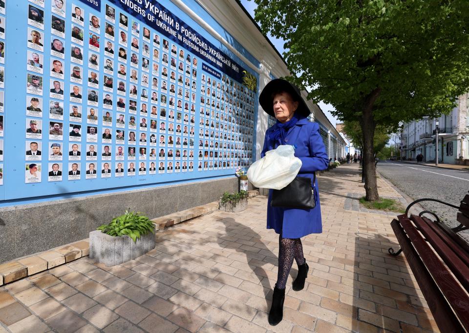 A Ukrainian woman walks past thousands of photos of soldiers lost in battle with Russia over many years of conflict in Kyiv, Ukraine, on Wednesday, May 3, 2023. | Scott G Winterton, Deseret News