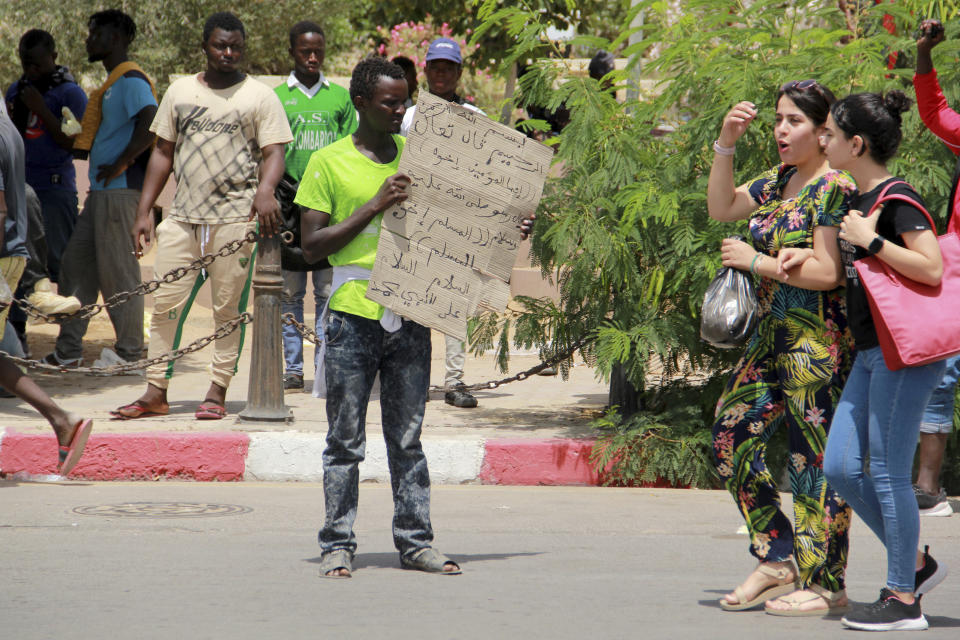 A migrant holds a placard reading "All muslims are brothers" during a gathering in Sfax, Tunisia's eastern coast, Friday, July 7, 2023. Tensions spiked dangerously in a Tunisian port city this week after three migrants were detained in the death of a local man, and there were reports of retaliation against Black foreigners and accounts of mass expulsions and alleged assaults by security forces. (AP Photo)