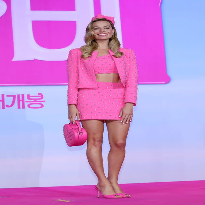 Margot in a pink bejeweled miniskirt suit with cropped top and jacket