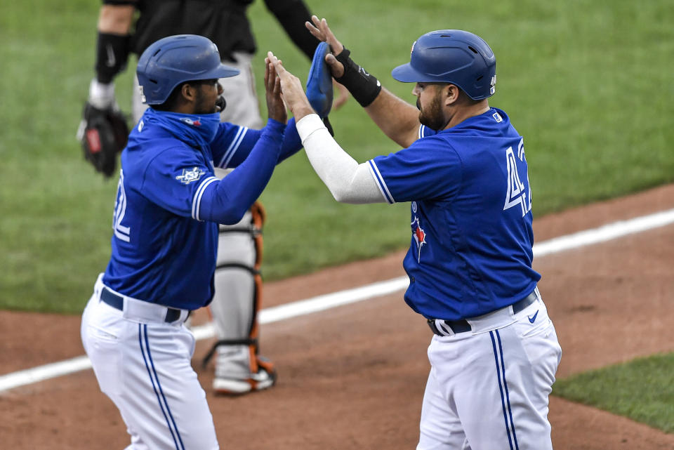 Toronto Blue Jays' Rowdy Tellez, right, and Teoscar Hernández celebrate after both scored against the Baltimore Orioles on a single by Vladimir Guerrero Jr. during the first inning of a baseball game in Buffalo, N.Y., Saturday, Aug. 29, 2020. (AP Photo/Adrian Kraus)