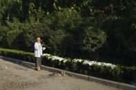 Sun Jiayun lays goods salvaged from her daughter's shop in the nearby Yubei Agricultural and Aquatic Products World to dry in the sun in Xinxiang in central China's Henan Province, Monday, July 26, 2021. Record rain in Xinxiang last week left the produce and seafood market soaked in water. Dozens of people died in the floods that immersed large swaths of central China's Henan province in water. (AP Photo/Dake Kang)