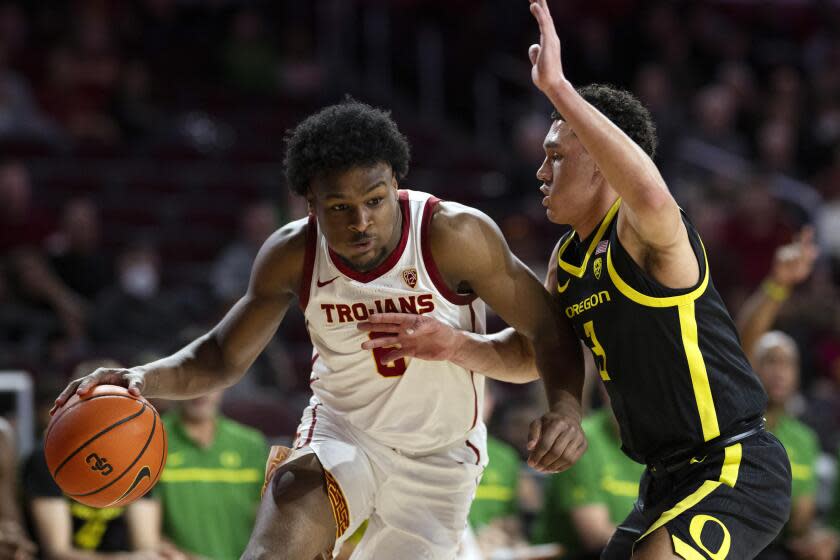 USC guard Bronny James, left, drives to the basket in front of Oregon guard Jackson Shelstad.