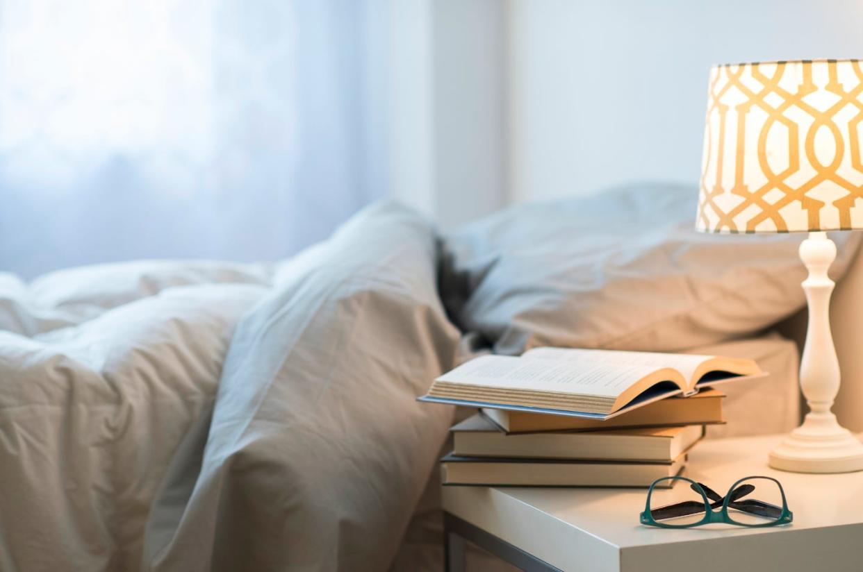 usa, new jersey, bed with lamp, books and glasses on bedside table