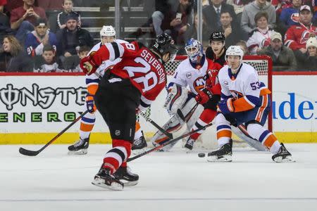 Feb 7, 2019; Newark, NJ, USA; New Jersey Devils defenseman Damon Severson (28) takes a shot while New York Islanders goaltender Thomas Greiss (1) looks around a screen for the puck during the third period at Prudential Center. Mandatory Credit: Ed Mulholland-USA TODAY Sports