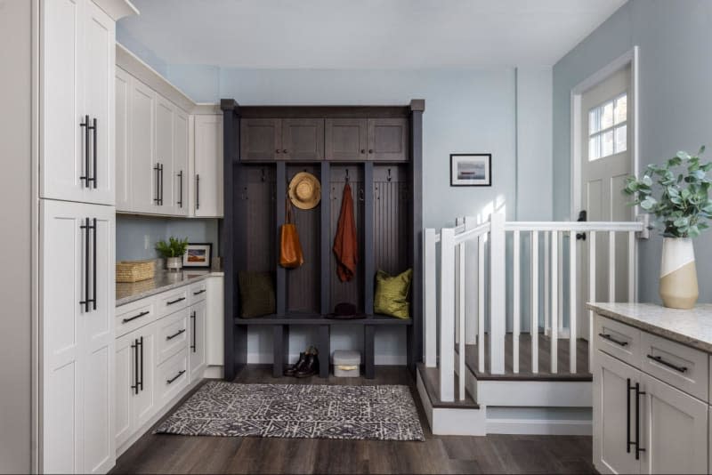 Black built in cubbies, white cabinets with countertop, dark wood floors