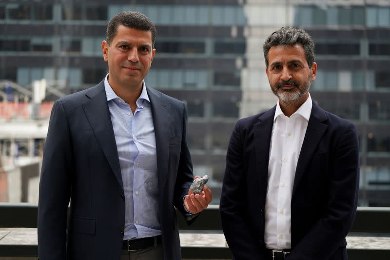 Rafael Papismedov and Oded Mansori pose with an over 1,000-carat uncut stone by Lucara Diamond during a press availability in New York