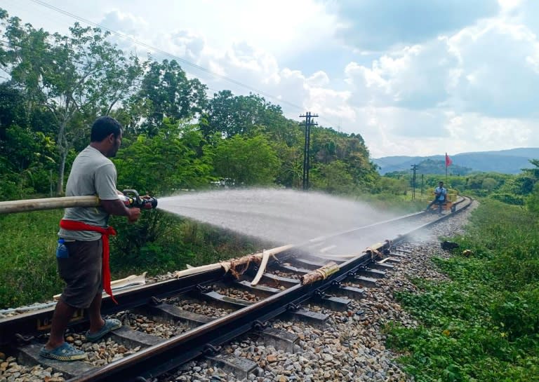 Thai railway workers doused the melting tracks with water to try to bend them back into shape (Handout)