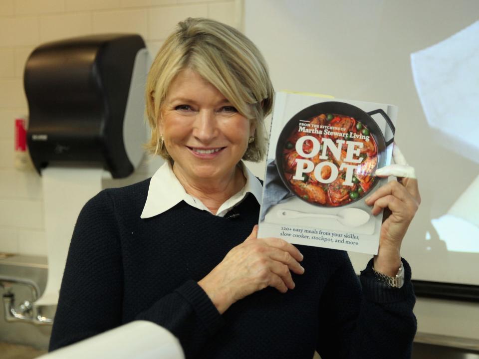 Martha Stewart poses with one of her cookbooks in 2014