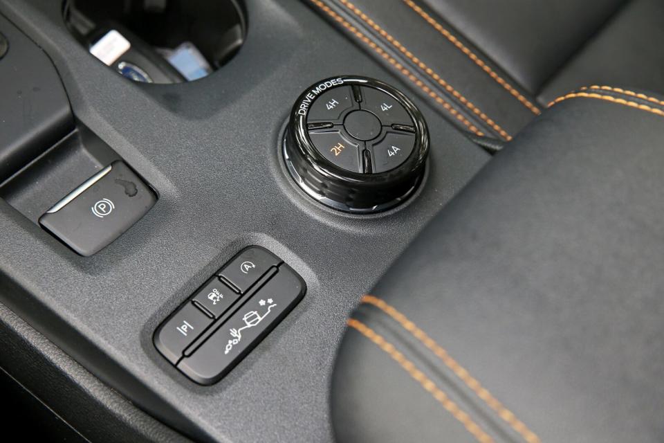 中央鞍座後方左側為自動停車輔助與引擎怠速啟閉控制按鍵，右側則是動態行車模式切換旋鈕，而旋鈕中間則2H/4H/4L/4A加力箱的切換按鍵。